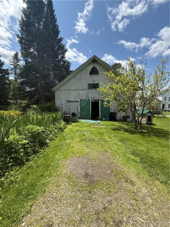 3679 County Highway 35, Middlefield, NY 13450 - view of home's exterior featuring an outdoor structure, a lawn, and board and batten siding