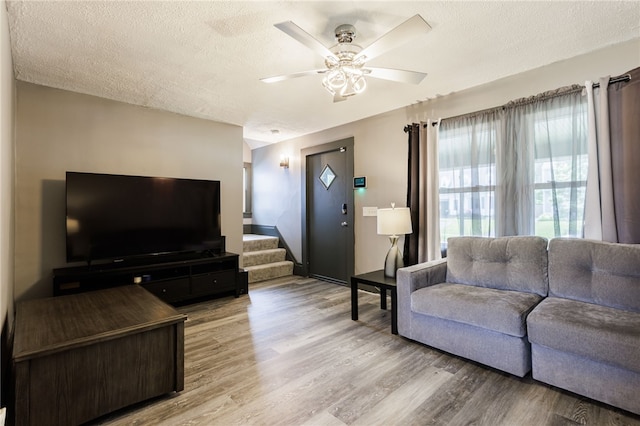 74 Everett St, Greece, NY 14615 - living area featuring light wood-style flooring, a textured ceiling, a ceiling fan, and stairs