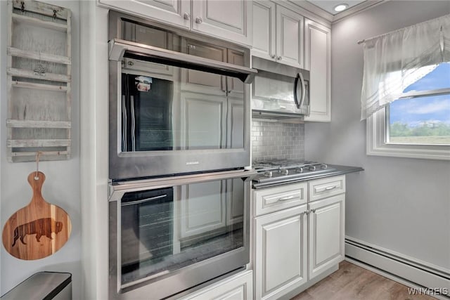 2194 Rte 39, Sheridan, NY 14062 - kitchen featuring a baseboard heating unit, appliances with stainless steel finishes, backsplash, light wood-style flooring, and white cabinetry