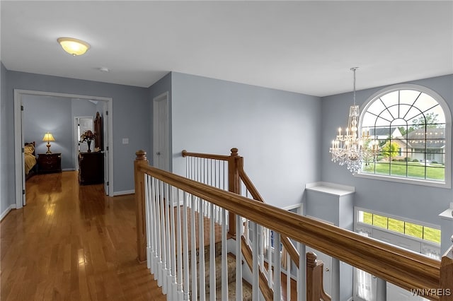6017 Corinne Ln, Clarence, NY 14032 - hall with an upstairs landing, a chandelier, wood finished floors, and baseboards