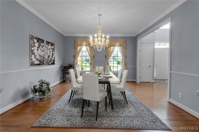 6017 Corinne Ln, Clarence, NY 14032 - dining space with a chandelier, wood finished floors, crown molding, and baseboards