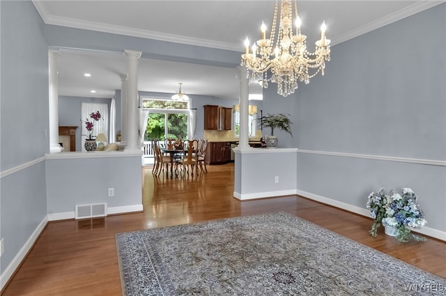 6017 Corinne Ln, Clarence, NY 14032 - dining space with ornate columns, wood finished floors, ornamental molding, a chandelier, and baseboards