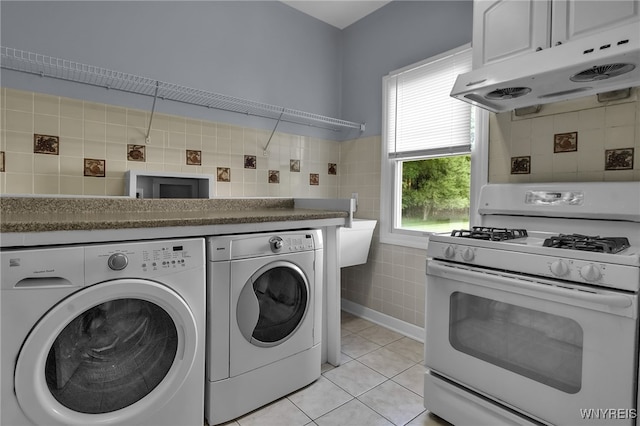 6017 Corinne Ln, Clarence, NY 14032 - washroom featuring washing machine and dryer, tile walls, and light tile patterned flooring