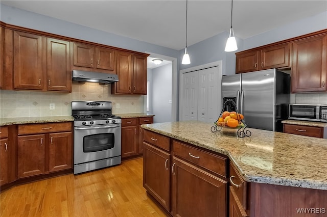 6017 Corinne Ln, Clarence, NY 14032 - kitchen featuring stainless steel appliances, ventilation hood, light wood finished floors, decorative backsplash, and hanging light fixtures