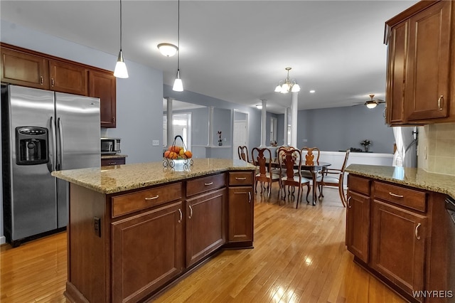 6017 Corinne Ln, Clarence, NY 14032 - kitchen with stainless steel appliances, light wood-style floors, decorative light fixtures, and a kitchen island