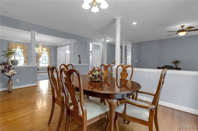 6017 Corinne Ln, Clarence, NY 14032 - dining room with baseboards, a chandelier, light wood finished floors, and ornate columns