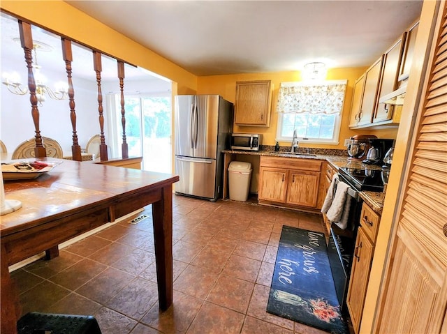 508 Countess Dr, Henrietta, NY 14586 - kitchen featuring stainless steel appliances, a sink, under cabinet range hood, dark tile patterned floors, and dark stone countertops
