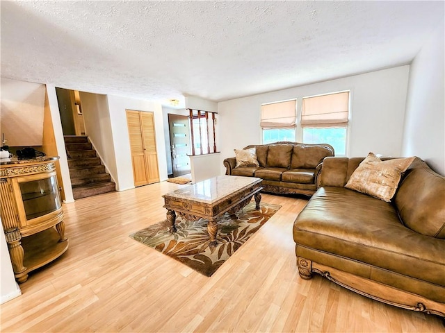 508 Countess Dr, Henrietta, NY 14586 - living area with light wood-style flooring, stairs, and a textured ceiling
