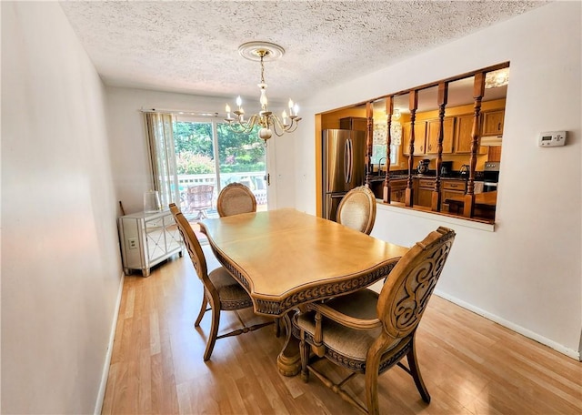 508 Countess Dr, Henrietta, NY 14586 - dining room with a chandelier, light wood-style flooring, a textured ceiling, and baseboards