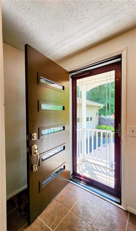 508 Countess Dr, Henrietta, NY 14586 - doorway with tile patterned floors and a textured ceiling