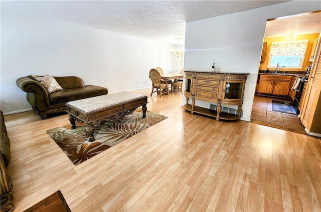 508 Countess Dr, Henrietta, NY 14586 - living area with a chandelier, light wood-style floors, and a textured ceiling