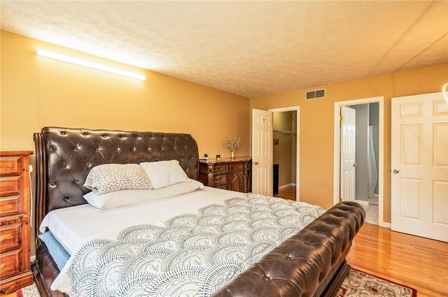 53 Toni Ter, Chili, NY 14624 - bedroom with wood finished floors, a spacious closet, a textured ceiling, and a closet