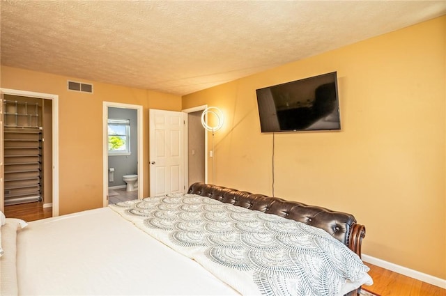 53 Toni Ter, Chili, NY 14624 - bedroom with wood finished floors, a textured ceiling, and ensuite bath