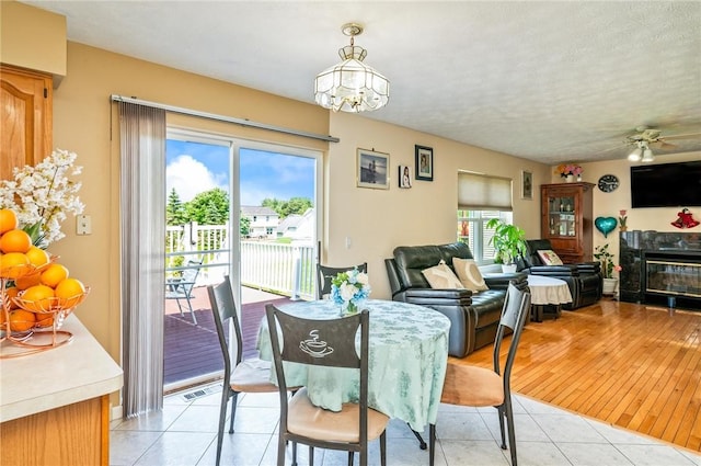 53 Toni Ter, Chili, NY 14624 - dining space with a chandelier, a tiled fireplace, light tile patterned flooring, and ceiling fan