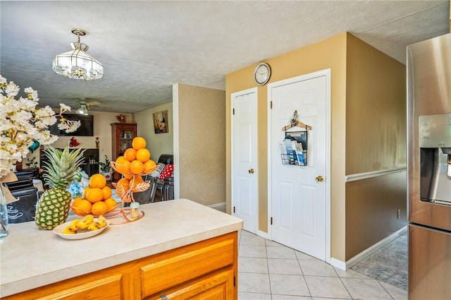 53 Toni Ter, Chili, NY 14624 - kitchen featuring light countertops, stainless steel refrigerator with ice dispenser, light tile patterned floors, brown cabinets, and a textured ceiling