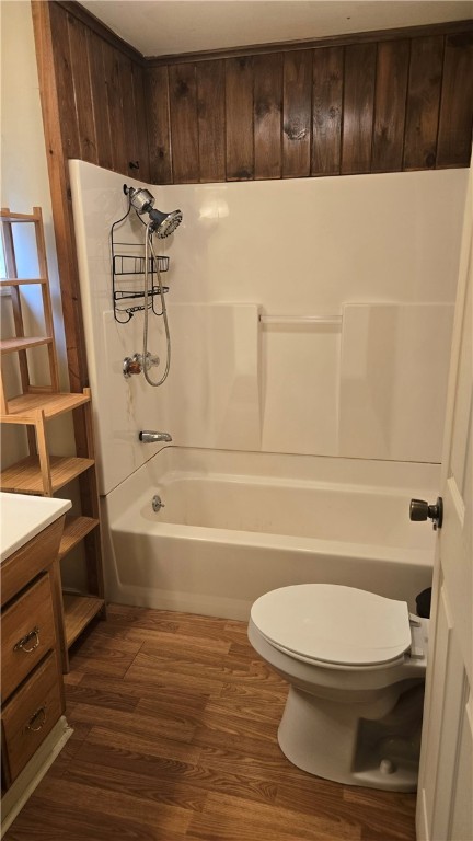 3976 Eddy Rd, Thurston, NY 14801 - bathroom featuring toilet, wood finished floors, vanity, and shower / washtub combination
