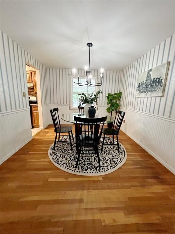 30 Sibley Dr, West Seneca, NY 14224 - dining area with wallpapered walls, wood finished floors, a chandelier, and a wainscoted wall
