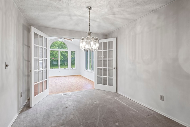69 Tree Brook Dr, Penfield, NY 14625 - unfurnished dining area featuring french doors, carpet floors, baseboards, a textured ceiling, and a chandelier