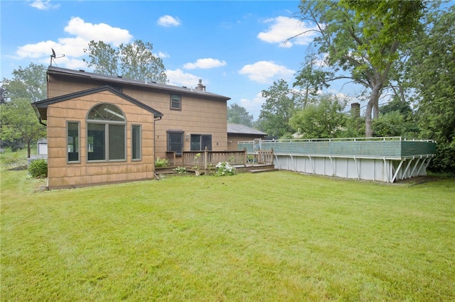 69 Tree Brook Dr, Penfield, NY 14625 - back of property with a deck, a yard, and a swimming pool