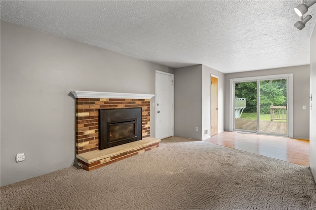 69 Tree Brook Dr, Penfield, NY 14625 - unfurnished living room featuring carpet flooring, a brick fireplace, and a textured ceiling