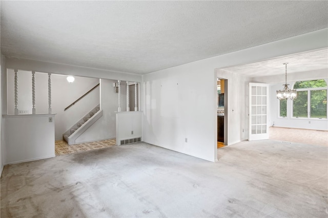 69 Tree Brook Dr, Penfield, NY 14625 - unfurnished room featuring a chandelier, stairs, carpet flooring, and a textured ceiling