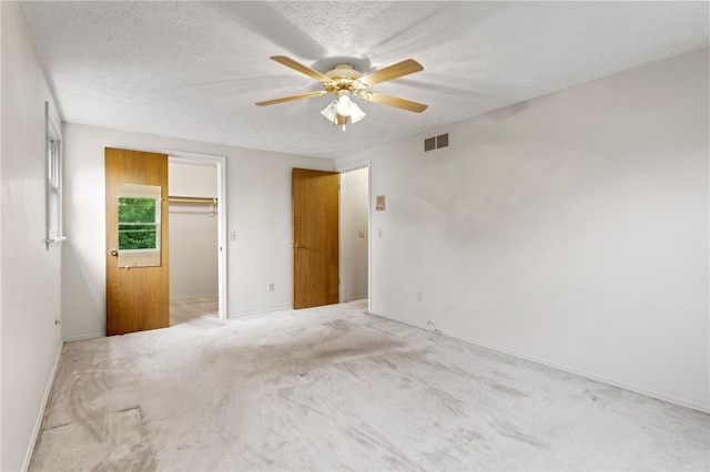69 Tree Brook Dr, Penfield, NY 14625 - unfurnished bedroom with a ceiling fan, a textured ceiling, carpet flooring, a walk in closet, and a closet
