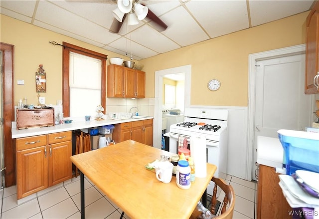 132 Weiss St, Buffalo, NY 14206 - kitchen with a ceiling fan, a sink, light tile patterned floors, gas range gas stove, and wainscoting