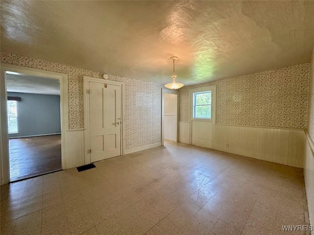 11920 Clarence Center Rd, Newstead, NY 14001 - empty room featuring wainscoting, wallpapered walls, and tile patterned floors