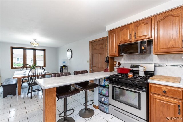201 Bernadette, West Seneca, NY 14224 - kitchen with gas stove, black microwave, a breakfast bar area, and light countertops