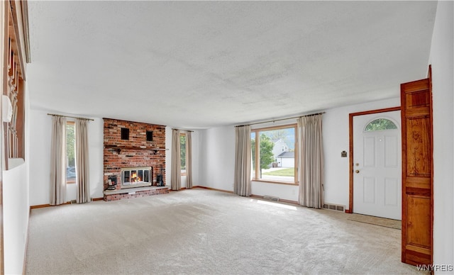 63 Princeton Ct, Cheektowaga, NY 14225 - unfurnished living room with a textured ceiling, carpet flooring, a brick fireplace, and baseboards