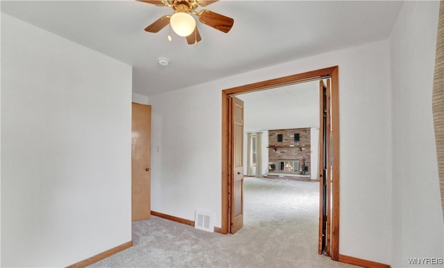 63 Princeton Ct, Cheektowaga, NY 14225 - spare room with light colored carpet, baseboards, ceiling fan, and a fireplace