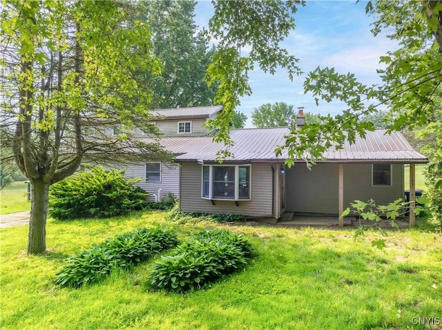 1010 Simmons Rd, Sterling, NY 13156 - view of front of home with metal roof, a front yard, and a chimney