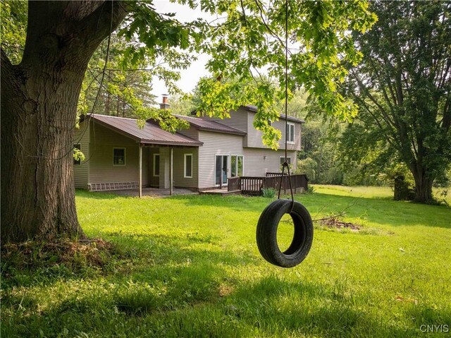 1010 Simmons Rd, Sterling, NY 13156 - back of house featuring a lawn, metal roof, and a wooden deck