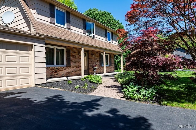 18 Tree Top Dr, Penfield, NY 14625 - view of front of property with brick siding, a porch, roof with shingles, and asphalt driveway