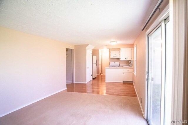 18 Tree Top Dr, Penfield, NY 14625 - unfurnished living room featuring light carpet and baseboards