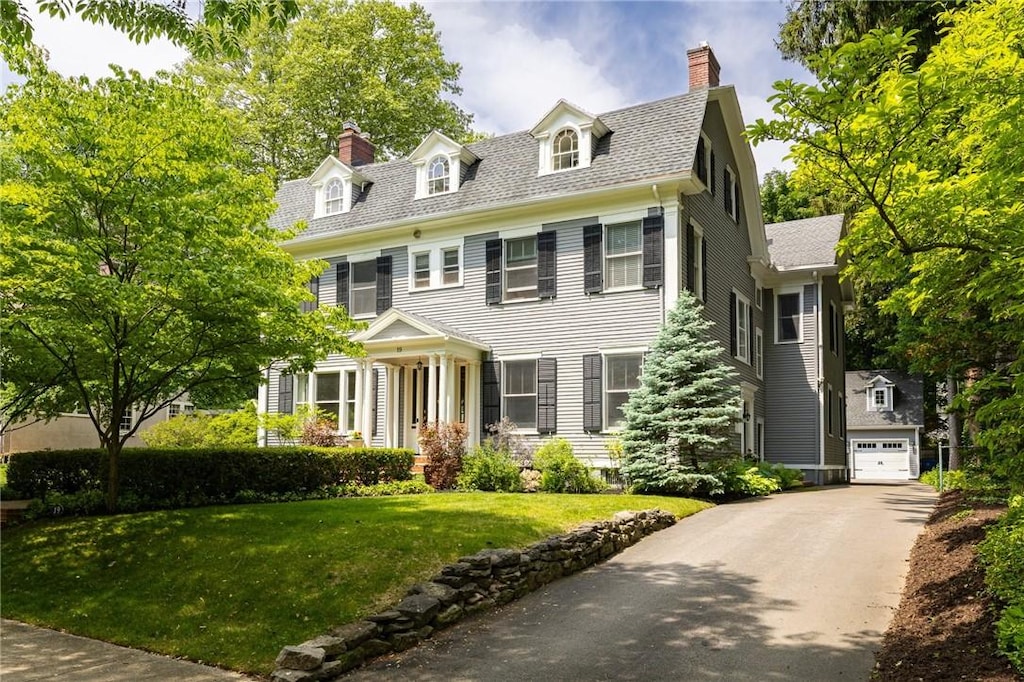 19 E Blvd, Rochester, NY 14610 - view of front of property with a chimney, a front yard, asphalt driveway, and a garage