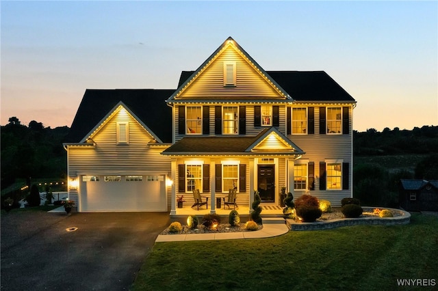 392 Quarry Run, Grand Island, NY 14072 - view of front facade with covered porch, asphalt driveway, a lawn, and a garage