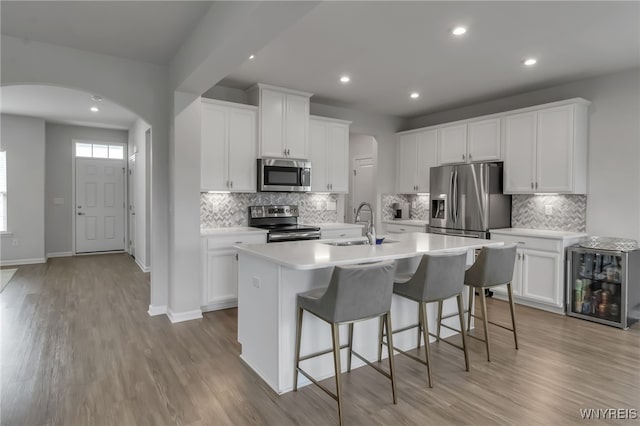 392 Quarry Run, Grand Island, NY 14072 - kitchen featuring stainless steel appliances, arched walkways, a kitchen island with sink, a sink, and recessed lighting