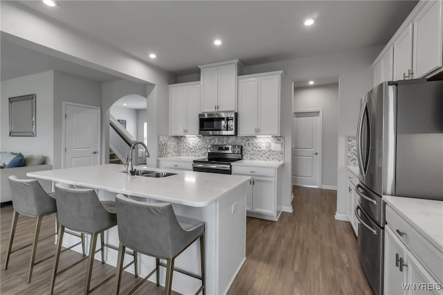 392 Quarry Run, Grand Island, NY 14072 - kitchen with appliances with stainless steel finishes, a sink, arched walkways, backsplash, and light countertops