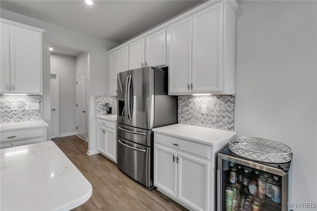392 Quarry Run, Grand Island, NY 14072 - kitchen with stainless steel fridge with ice dispenser, backsplash, white cabinets, wood finished floors, and wine cooler