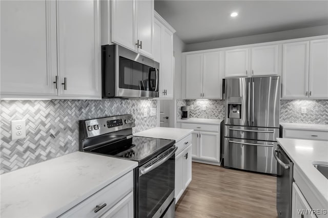 392 Quarry Run, Grand Island, NY 14072 - kitchen with appliances with stainless steel finishes, backsplash, white cabinetry, wood finished floors, and recessed lighting