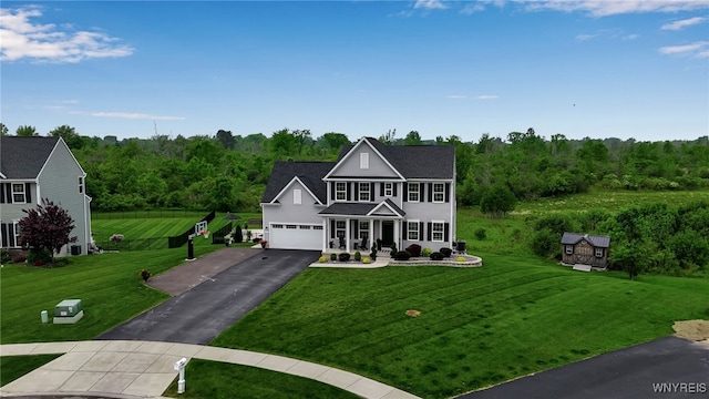 392 Quarry Run, Grand Island, NY 14072 - view of front of house featuring asphalt driveway, a front lawn, a forest view, and covered porch