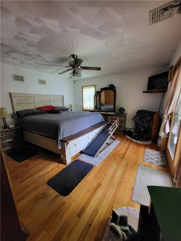 104 Mcclure Dr, Sanford, NY 13754 - bedroom featuring a wood stove, wood finished floors, and a ceiling fan