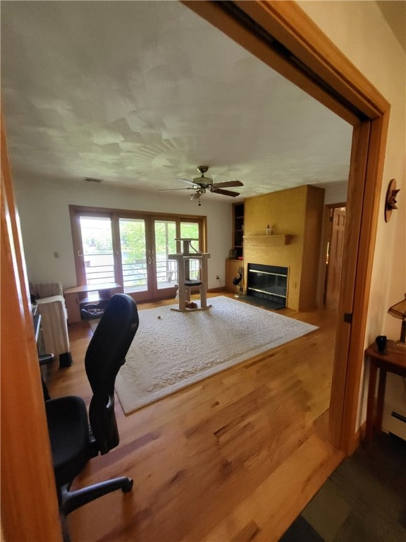 104 Mcclure Dr, Sanford, NY 13754 - office featuring a fireplace with flush hearth, wood finished floors, and a ceiling fan