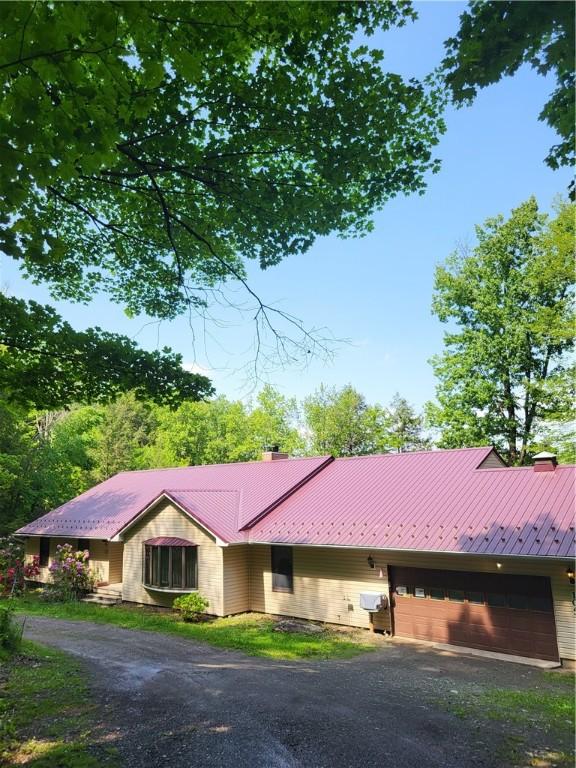 104 Mcclure Dr, Sanford, NY 13754 - view of front of property with a chimney, a garage, driveway, and a metal roof