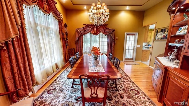 3248 Lockport Olcott Rd, Newfane, NY 14108 - dining area with a chandelier, light wood finished floors, a towering ceiling, and baseboards