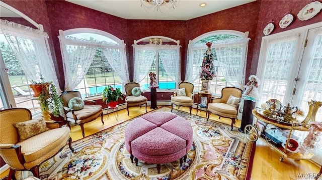 3248 Lockport Olcott Rd, Newfane, NY 14108 - living area featuring healthy amount of natural light, a chandelier, wood finished floors, and baseboard heating