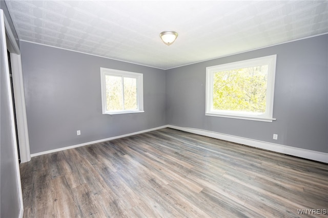 6817 Revere Dr, Evans, NY 14047 - empty room featuring wood finished floors and a baseboard heating unit