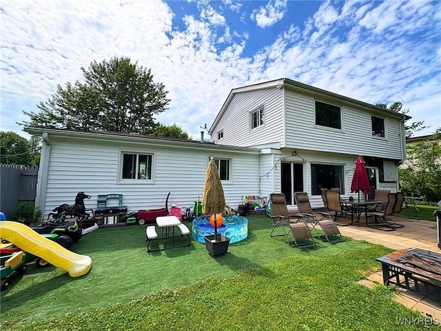 6817 Revere Dr, Evans, NY 14047 - back of property featuring a lawn, a patio, an outdoor fire pit, and a playground