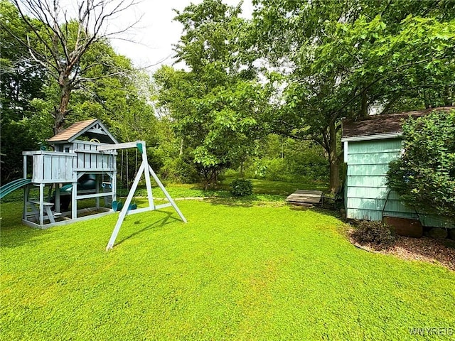 6817 Revere Dr, Evans, NY 14047 - view of green lawn with a playground and view of wooded area